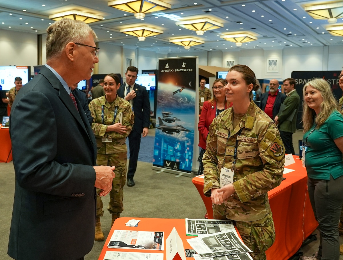 Senior Airman Erika Gustafson, AFWERX Spark, briefs Dr. Troy Meink, Secretary of the Air Force, during the Air, Space and Cyber Conference at the Gaylord National Resort and Convention Center in National Harbor, Maryland, on Sept. 24, 2025.