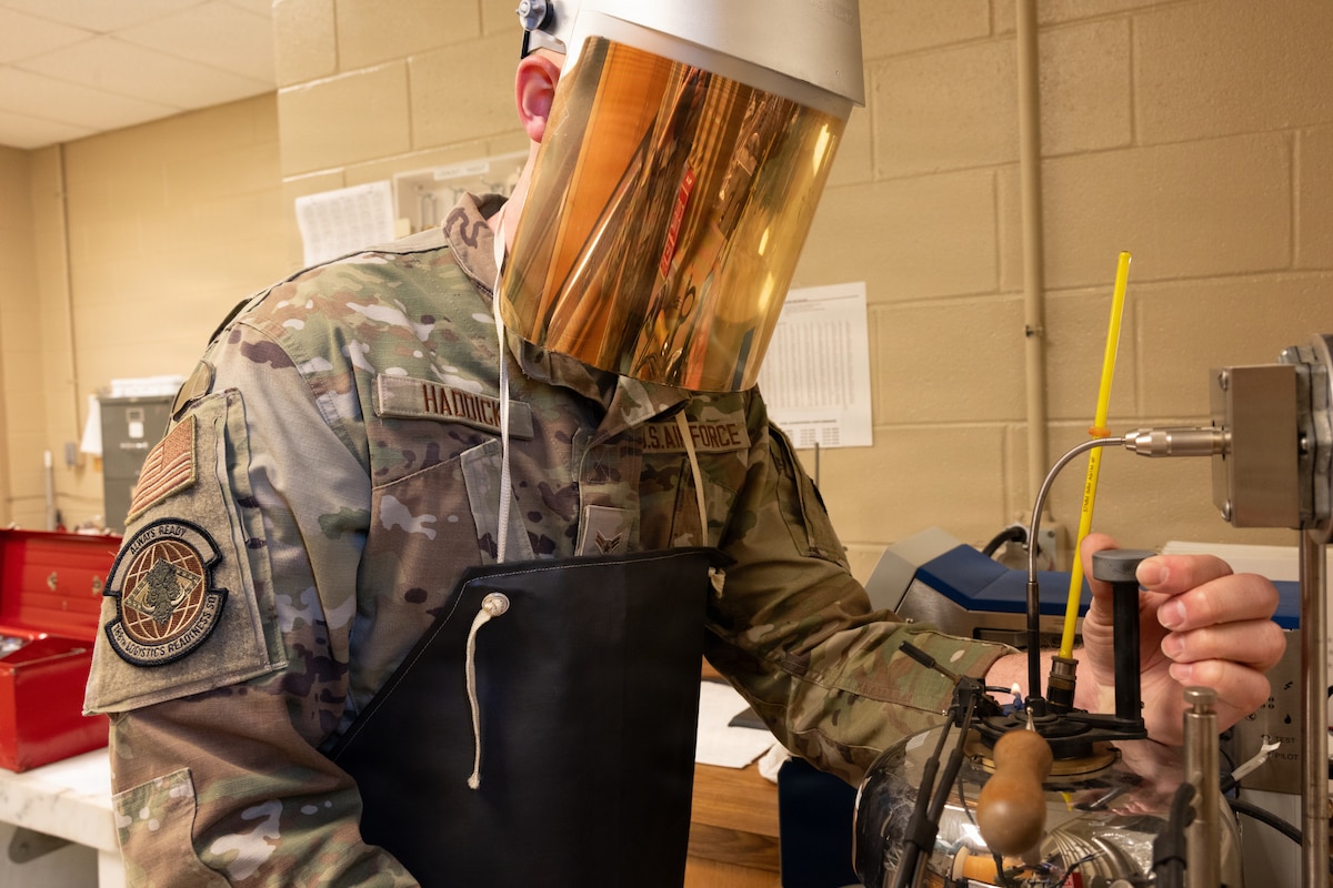 A fuels management specialist with the Air National Guard inspects jet fuel.