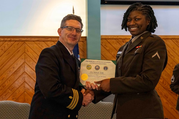 251216-N-JC800-1034 YORKTOWN, Virginia (Dec. 16, 2025) - Cmdr. Joshua Keil, Dean, Tri-Service Optician School, presents a certificate of completion to U.S. Army Pvt. Makayla Kelly during the graduation ceremony for the TOPS Class 25010, Dec. 16. (U.S. Navy photo by Mass Communication Specialist 1st Class Heath Zeigler/Released)