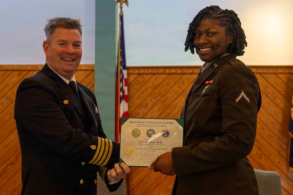 251216-N-JC800-1037 YORKTOWN, Virginia (Dec. 16, 2025) - Capt. James Corbett, commanding officer of Naval Medical Leader and Professional Development Command, presents a certificate of completion to U.S. Army Pvt. Makayla Kelly during the graduation ceremony for the Tri-Service Optician School Class 25010, Dec. 16. (U.S. Navy photo by Mass Communication Specialist 1st Class Heath Zeigler/Released)