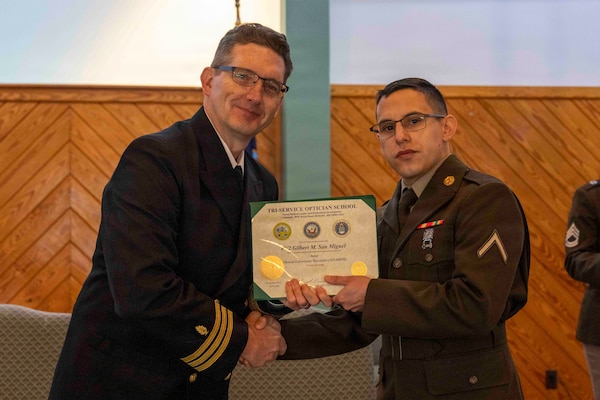 251216-N-JC800-1041 YORKTOWN, Virginia (Dec. 16, 2025) - Cmdr. Joshua Keil, Dean, Tri-Service Optician School, presents a certificate of completion to U.S. Army Pvt. Gilbert San Miguel during the graduation ceremony for the TOPS Class 25010, Dec. 16. (U.S. Navy photo by Mass Communication Specialist 1st Class Heath Zeigler/Released)