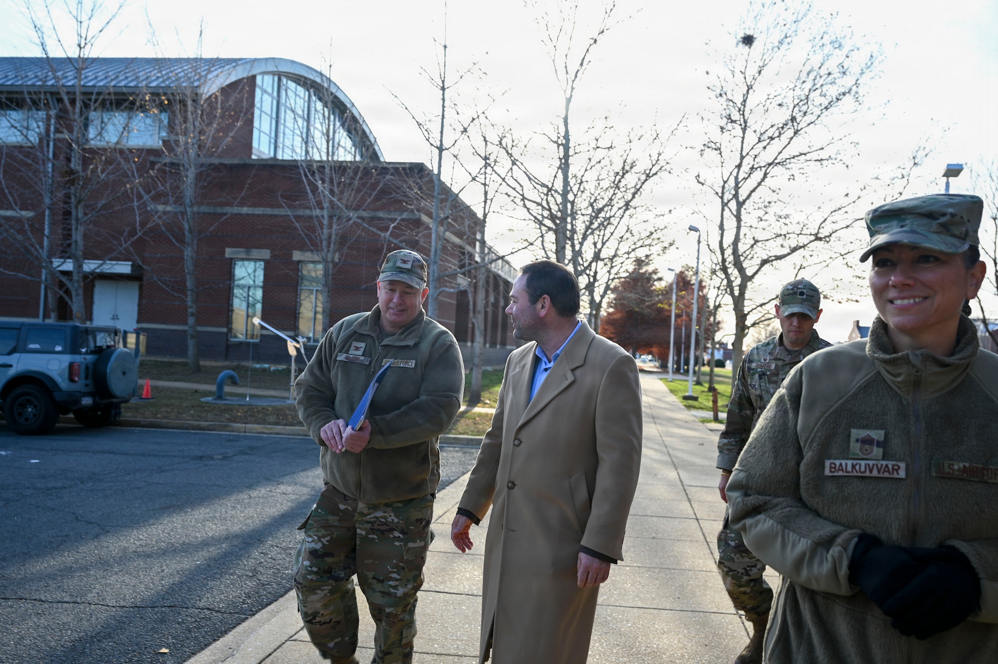 U.S. Air Force Col. James M. Clark, left, commander of Joint Base Anacostia-Bolling and the 11th Wing, discusses the conditions of base dormitories with Adam Dontz, center, Deputy Assistant Secretary of War for Housing, during a dormitory tour on Joint Base Anacostia-Bolling, Washington, D.C., Dec. 9, 2025. The group met to tour existing housing facilities and discuss housing improvement projects for JBAB. (U.S. Air force photo by Airman 1st Class Shanel Toussaint)