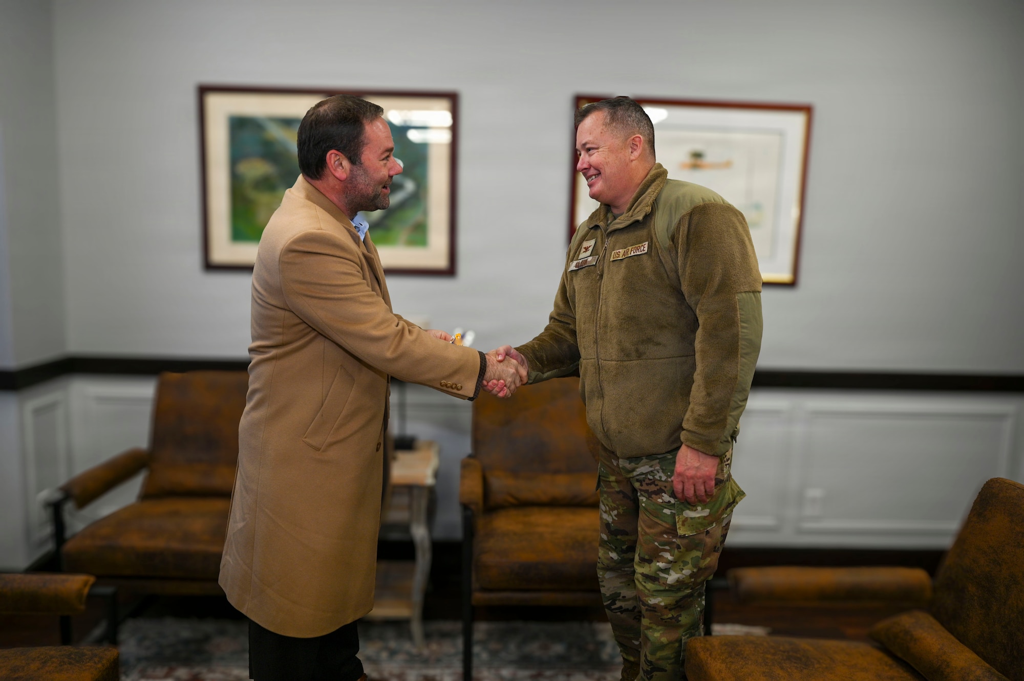 U.S. Air Force Col. James M. Clark, right, commander of Joint Base Anacostia-Bolling and the 11th Wing, coins Adam Dontz, left, Deputy Assistant Secretary of War for Housing, after the conclusion of a dormitory tour on Joint Base Anacostia-Bolling, Washington, D.C., Dec. 9, 2025. The base commander and base leadership met Dontz to tour existing facilities and discuss improvement projects for dormitory housing on JBAB. (U.S. Air force photo by Airman 1st Class Shanel Toussaint)