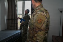 U.S. Air Force Col. James M. Clark, left, commander of Joint Base Anacostia-Bolling and the 11th Wing, inspects a dormitory room at JBAB, Washington, D.C., Dec. 9, 2025. Clark and other JBAB, 11th Wing, and Military Housing Office leadership toured unaccompanied service member housing with Adam Dontz, Deputy Assistant Secretary of War for Housing, and discussed improvement projects for dormitory housing on JBAB. (U.S. Air Force photo by Airman 1st Class Shanel Toussaint)