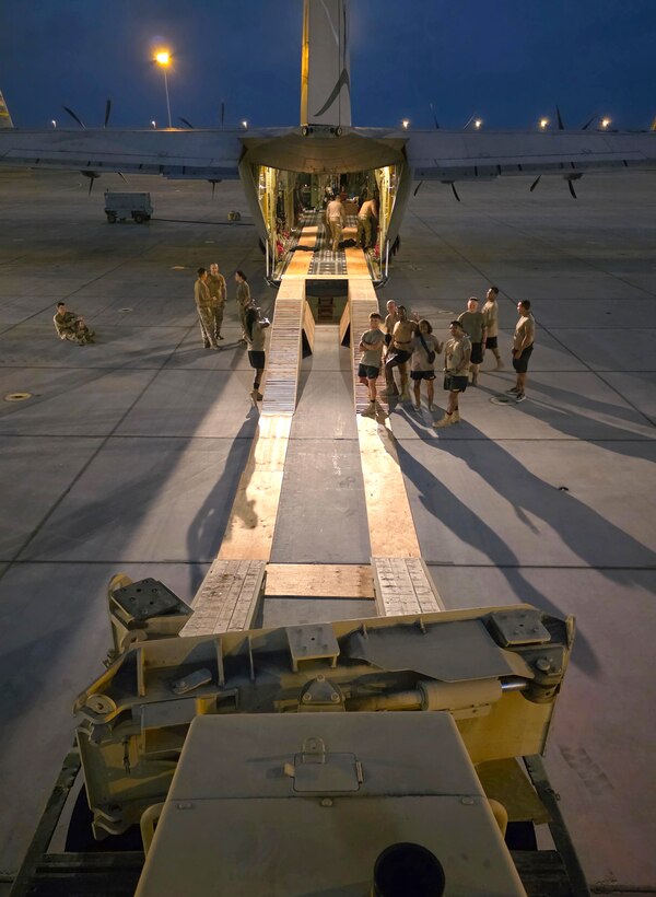Virginia National Guard Soldiers assigned to the Powhatan-based 180th Engineer Support Company, 276th Engineer Battalion, 329th Regional Support Group load a Caterpillar D6K Dozer onto a West Virginia Air National Guard C-130J Super Hercules
