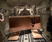 Virginia National Guard Soldiers assigned to the Powhatan-based 180th Engineer Support Company, 276th Engineer Battalion, 329th Regional Support Group load a Caterpillar D6K Dozer onto a West Virginia Air National Guard C-130J Super Hercules