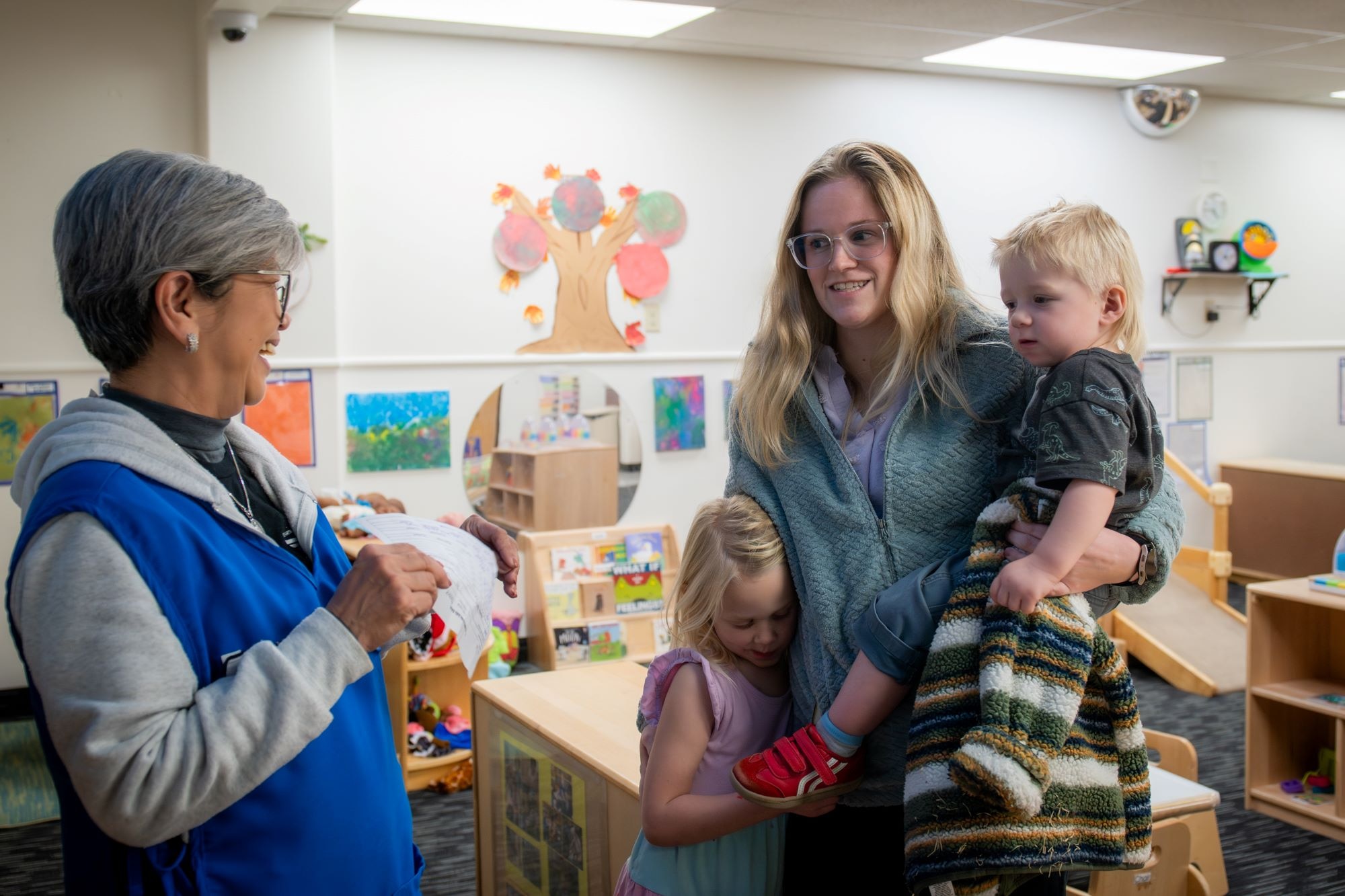 Air Force Test Center's Ashley Stiles, accompanied by daughter Ripley, picks up her son Maverick, from childcare provider Rowena Depaz, at the Child Development Center on Edwards Air Force Base, California, Jan. 6. (Photo by Giancarlo Casem)