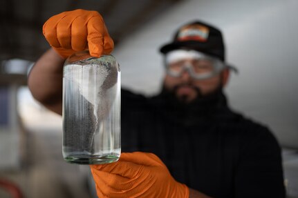 Rogelio Guerrero, 502d Logistics Readiness Squadron Fuels Flight quality assurance specialist, examines a fuel sample for clarity and contaminants at Joint Base San Antonio-Lackland, Texas, Jan. 6, 2026. Visual inspections are one of several quality control measures used to verify the condition of incoming fuel before it enters the installation’s supply system. (U.S. Air Force photo by Jonathan R. Mallard)