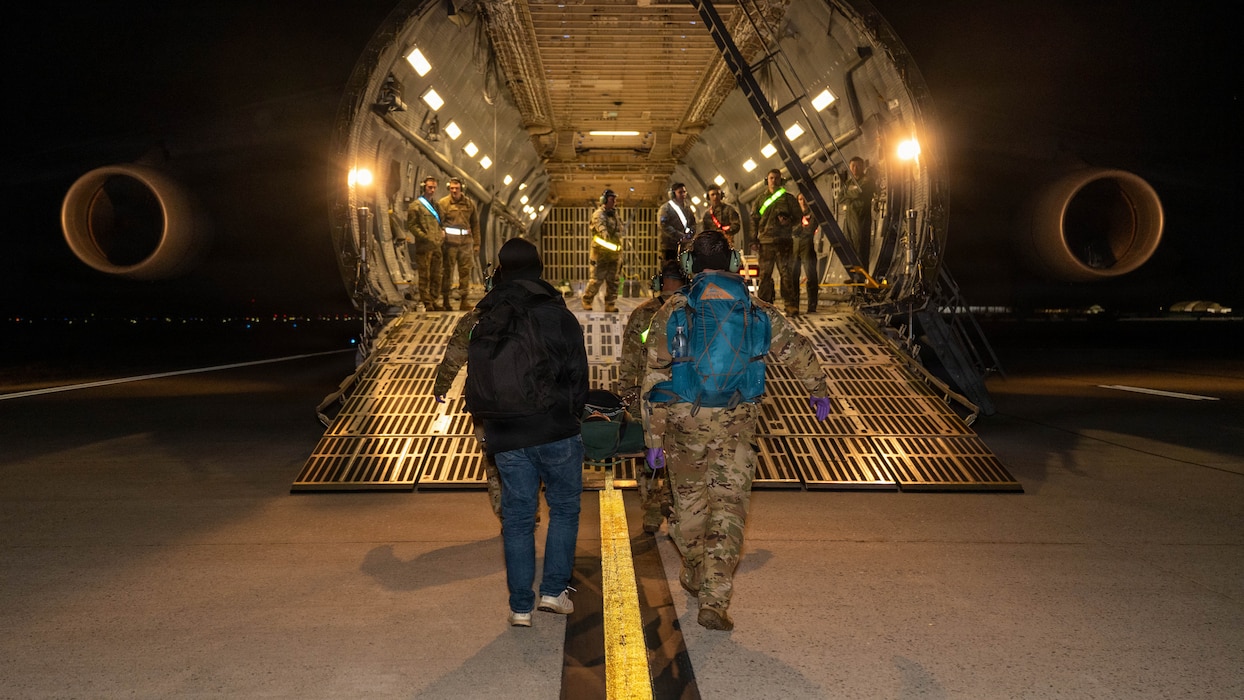 Airmen carry a simulated patient on a stretcher