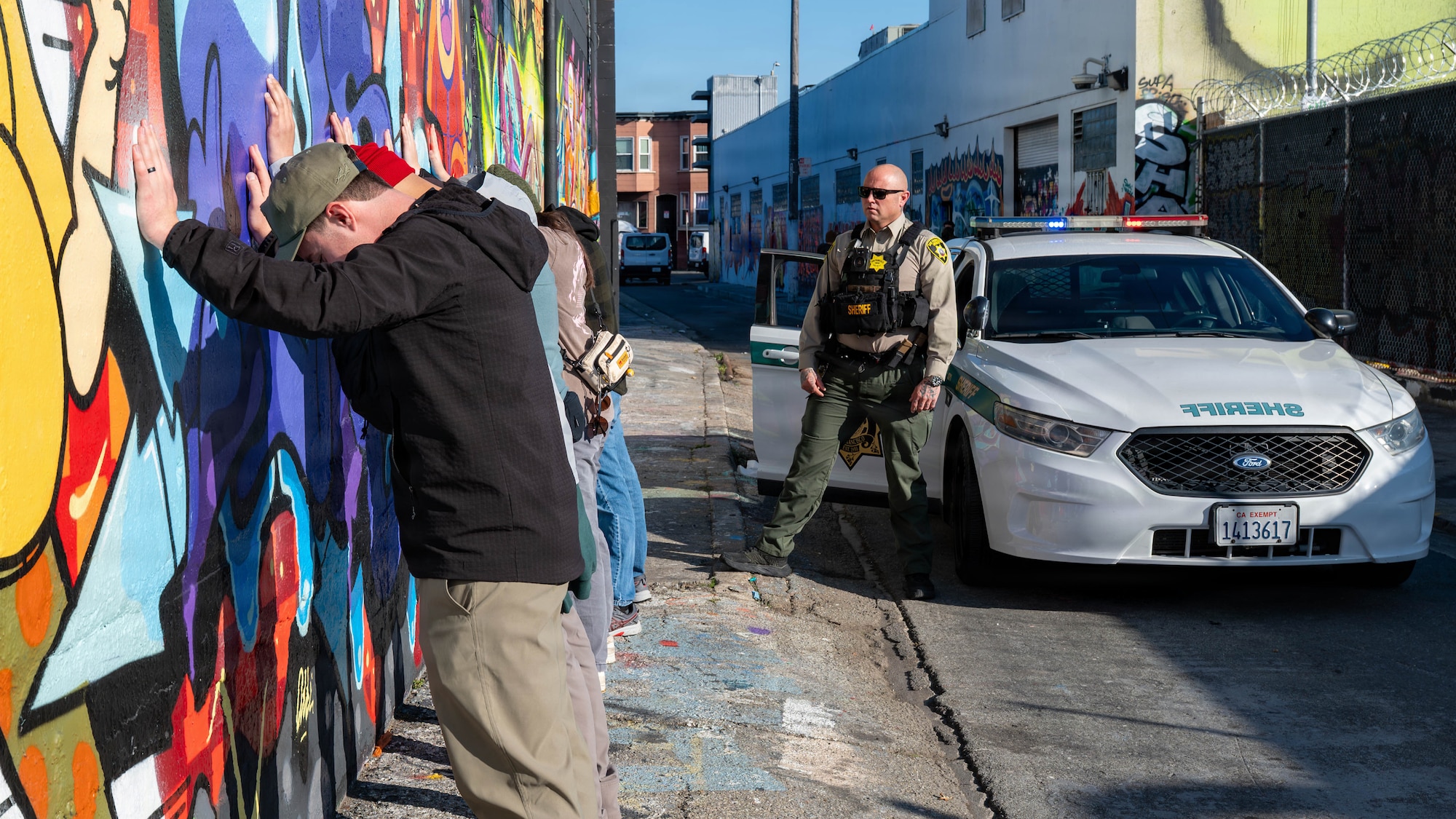 U.S. Airmen stand with their hands against a wall