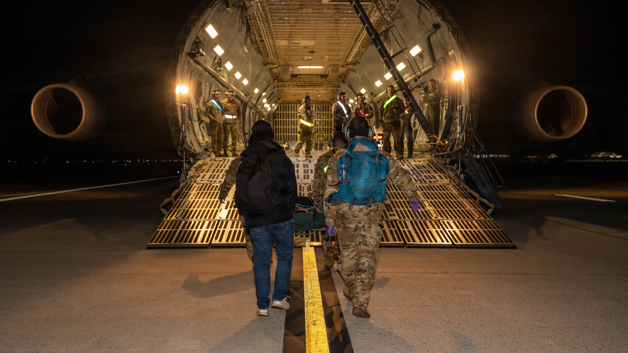 Airmen carry a simulated patient on a stretcher