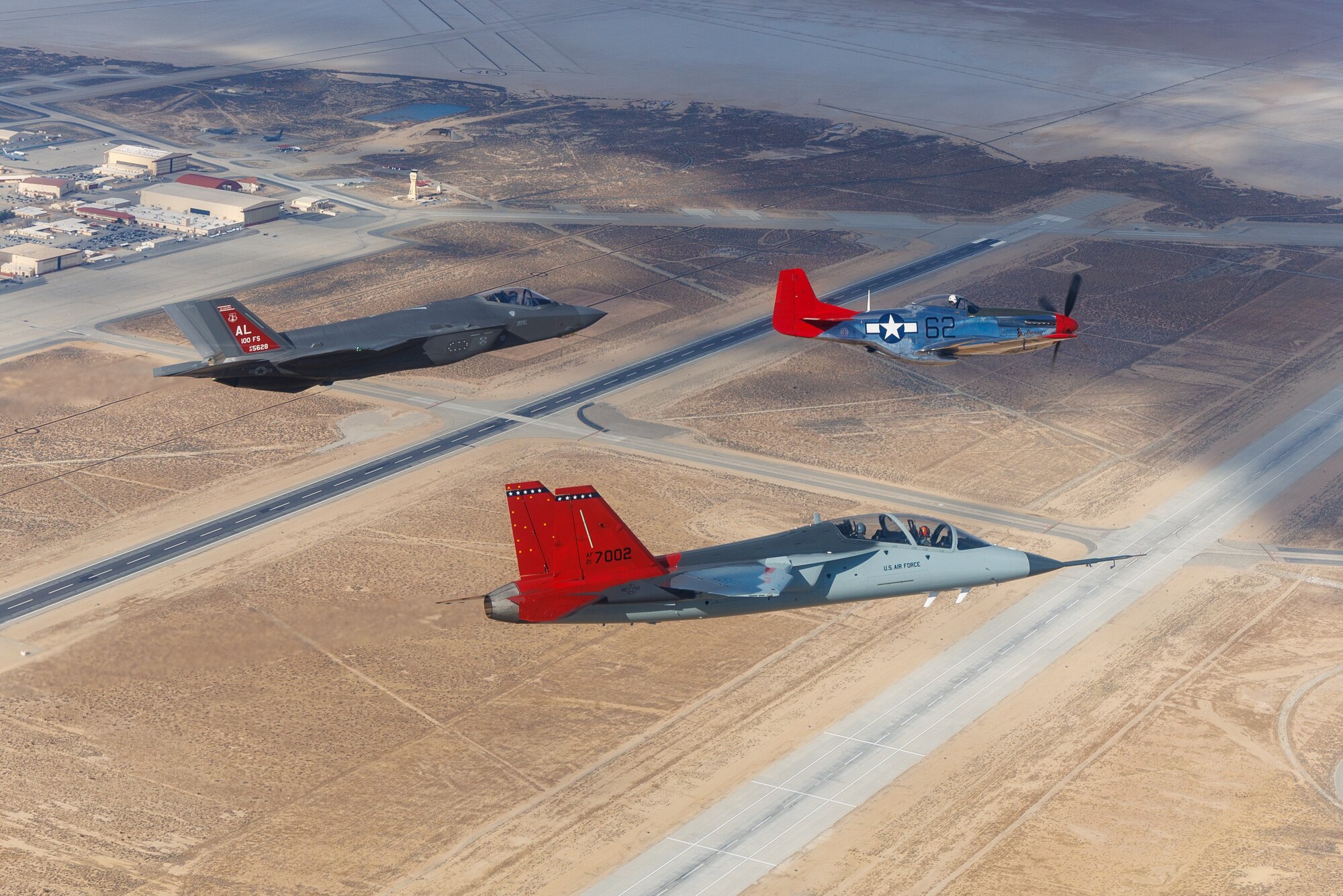 A T-7A Red Hawk from the 416th Flight Test Squadron, F-35A from the Alabama Air National Guard and P-51D Mustang from the Palm Springs Air and Space Museum fly in formation over Edwards Air Force Base after the 2025 Red Tail Rendezvous event.