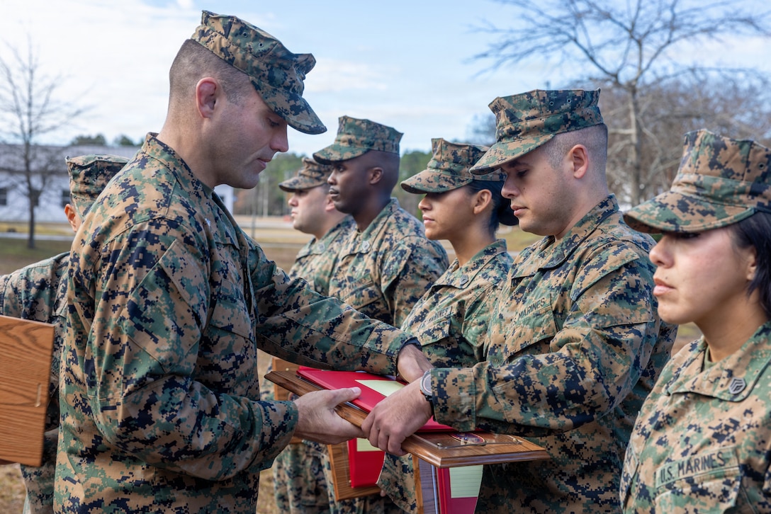 U.S. Marine Corps Lt. Col. James Blaul, left, the commanding officer of Ground Supply School, and a native of Wisconsin, presents an award to Gunnery Sgt. Matthew Perez, an instructor with GSS, and a native of New York, during an awards ceremony on Camp Gilbert H. Johnson, North Carolina