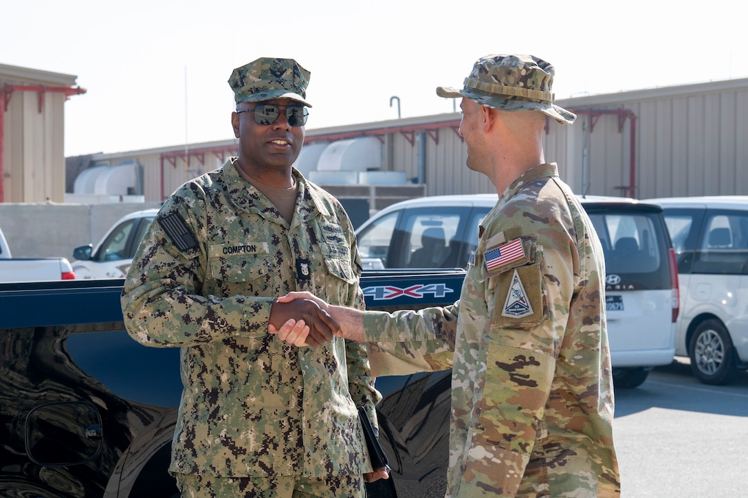 U.S. Navy Fleet Master Chief Lateef Compton, U.S. Central Command senior enlisted leader, shakes hands with a Guardian in the CENTCOM area of responsibility, Jan. 7, 2025. Compton visited multiple sites around the base and had lunch with Airmen and Guardians assigned to U.S. Space Forces - Central. (U.S. Air Force photo by Senior Airman Devlin Bishop)