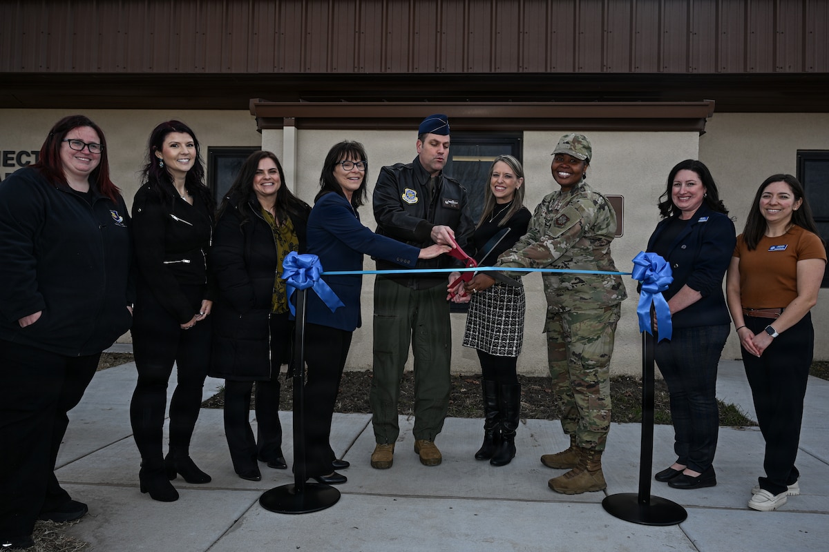 Team McConnell members pose for a photo during a ribbon cutting ceremony at McConnell Air Force Base, Kansas, Dec. 19, 2025. Representatives prepared to cut a ribbon, marking the opening of a new connect to care facility. (U.S. Air Force photo by Senior Airman Amelio Brown)