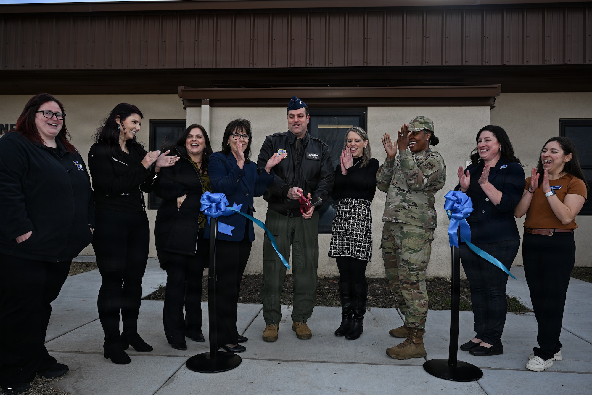 Team McConnell members celebrate during a ribbon cutting ceremony at McConnell Air Force Base, Kansas, Dec. 19, 2025. The celebration commemorated the opening of a new connect to care facility to prioritize care and support for Airmen. (U.S. Air Force photo by Senior Airman Amelio Brown)