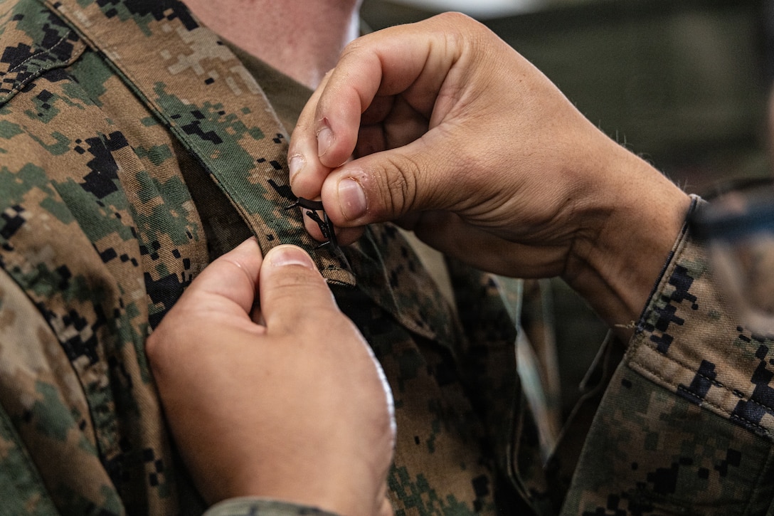 U.S. Marine Corps Lance Cpl. Joseph Newman, a rifleman with Lima Company, Battalion Landing Team 3/5, 11th Marine Expeditionary Unit, receives the rank of lance corporal in the well deck of San Antonio-class amphibious transport dock ship USS Portland (LPD 27), in the Pacific Ocean, Dec. 7, 2025. The 11th MEU is currently underway aboard the Boxer Amphibious Ready Group in the U.S. 3rd Fleet area of operations conducting integrated training that enhances lethality and warfighting readiness. (U.S. Marine Corps photo by Lance Cpl. Luke Rodriguez)