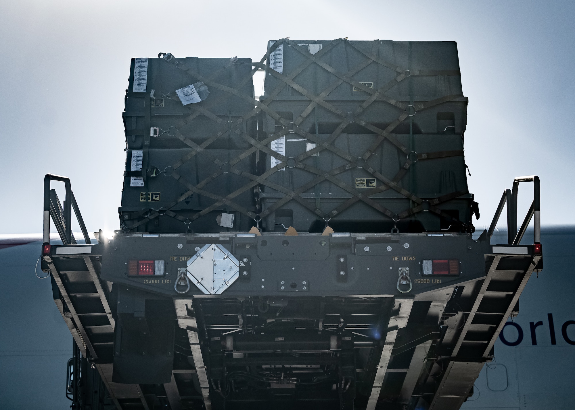 A K-Loader lowers cargo pallets from a Boeing 747 as Airmen from the 56th Fighter Wing and 161st Logistics Readiness Squadron manage the offload during a Special Assignment Airlift Mission