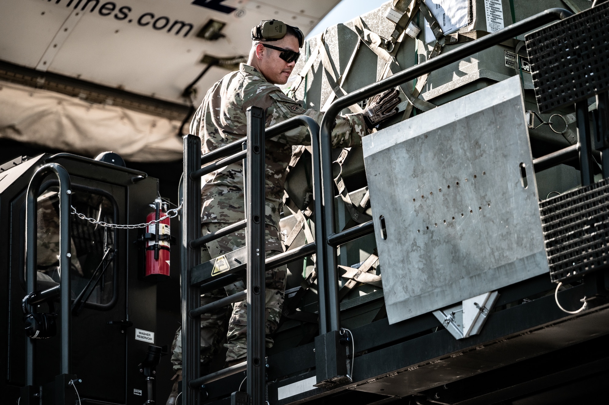 U.S. Air Force Tech. Sgt. Chana Lawlor, 56th Logistics Readiness Squadron passenger travel non-commissioned officer in charge, loads a cargo pallet of munitions tail kits during a Special Assignment Airlift Mission