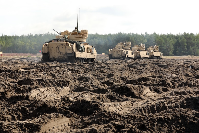 Bradley Fighting Vehicle crew members of 1st Squadron, 4th Cavalry Regiment (1-4), 1st Armored Brigade Combat Team, 1st Infantry Division align their tanks in mud as part of gunnery table VI qualifications to maintain readiness in Świętoszówka, Poland, Sept. 1, 2021. A rotational forward presence throughout Europe enables deterrence and defense against threats from any direction at any time. (U.S. Army photo by Sgt. 1st Class Chad Menegay/RELEASED)