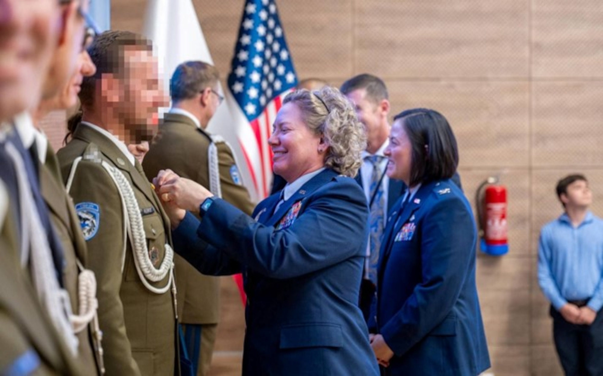 Brig. Gen. Amy Bumgarner, commander of the Air Force Office of Special Investigations, presents honors to members of Poland’s Cyberspace Defense Forces.