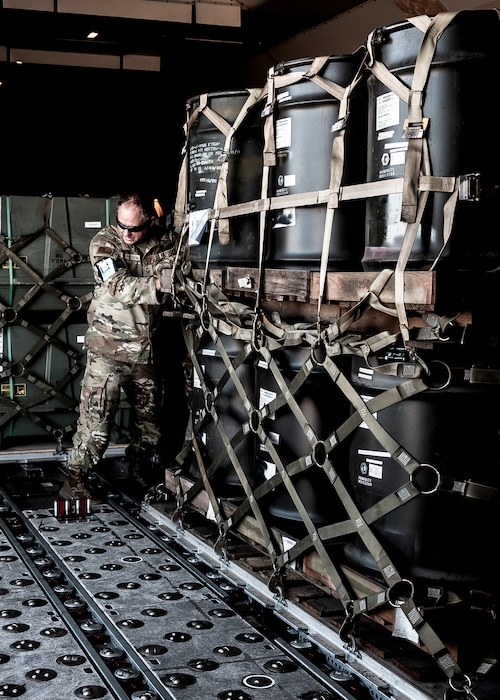 U.S. Air Force Senior Master Sgt. Matthew Van Rossem, 161st Logistics Readiness Squadron traffic management office superintendent, pushes a cargo pallet of munitions tail kits during Special Assignment Airlift Mission