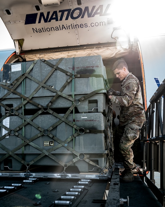 U.S. Air Force Tech. Sgt. Erik Swanberg, 161st Logistics Readiness Squadron air transportation operations center section supervisor, secures a cargo pallet of munitions tail kits during Special Assignment Airlift Mission