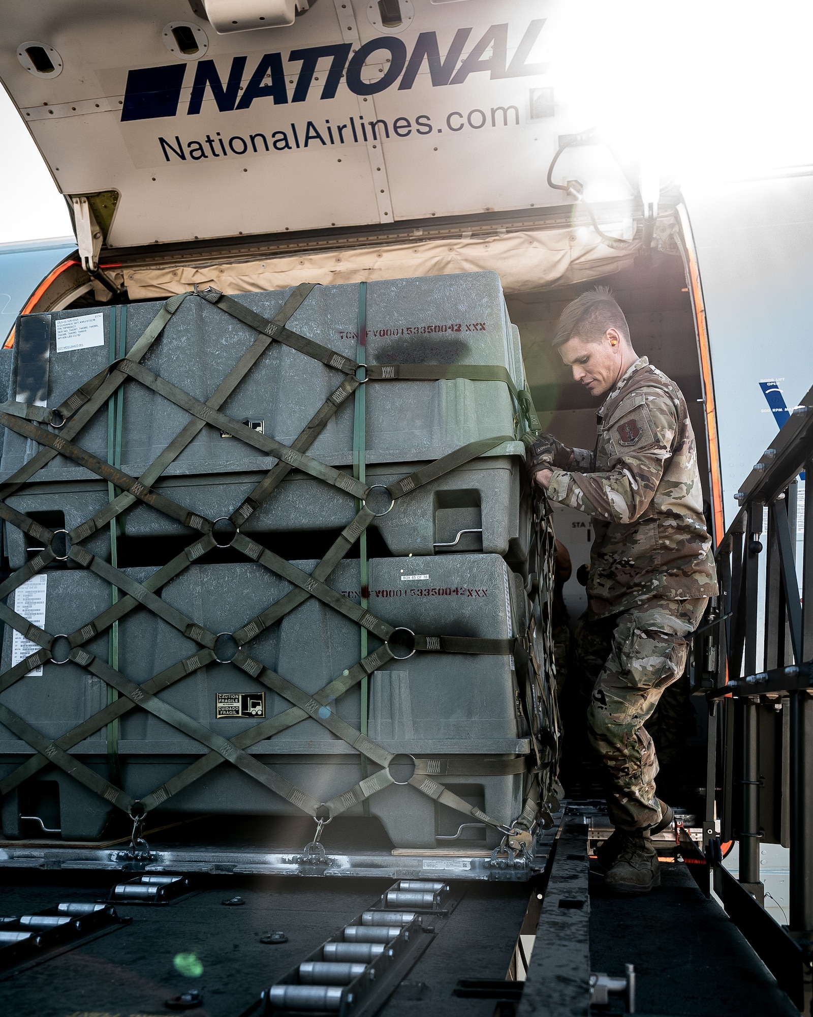U.S. Air Force Tech. Sgt. Erik Swanberg, 161st Logistics Readiness Squadron air transportation operations center section supervisor, secures a cargo pallet of munitions tail kits during Special Assignment Airlift Mission