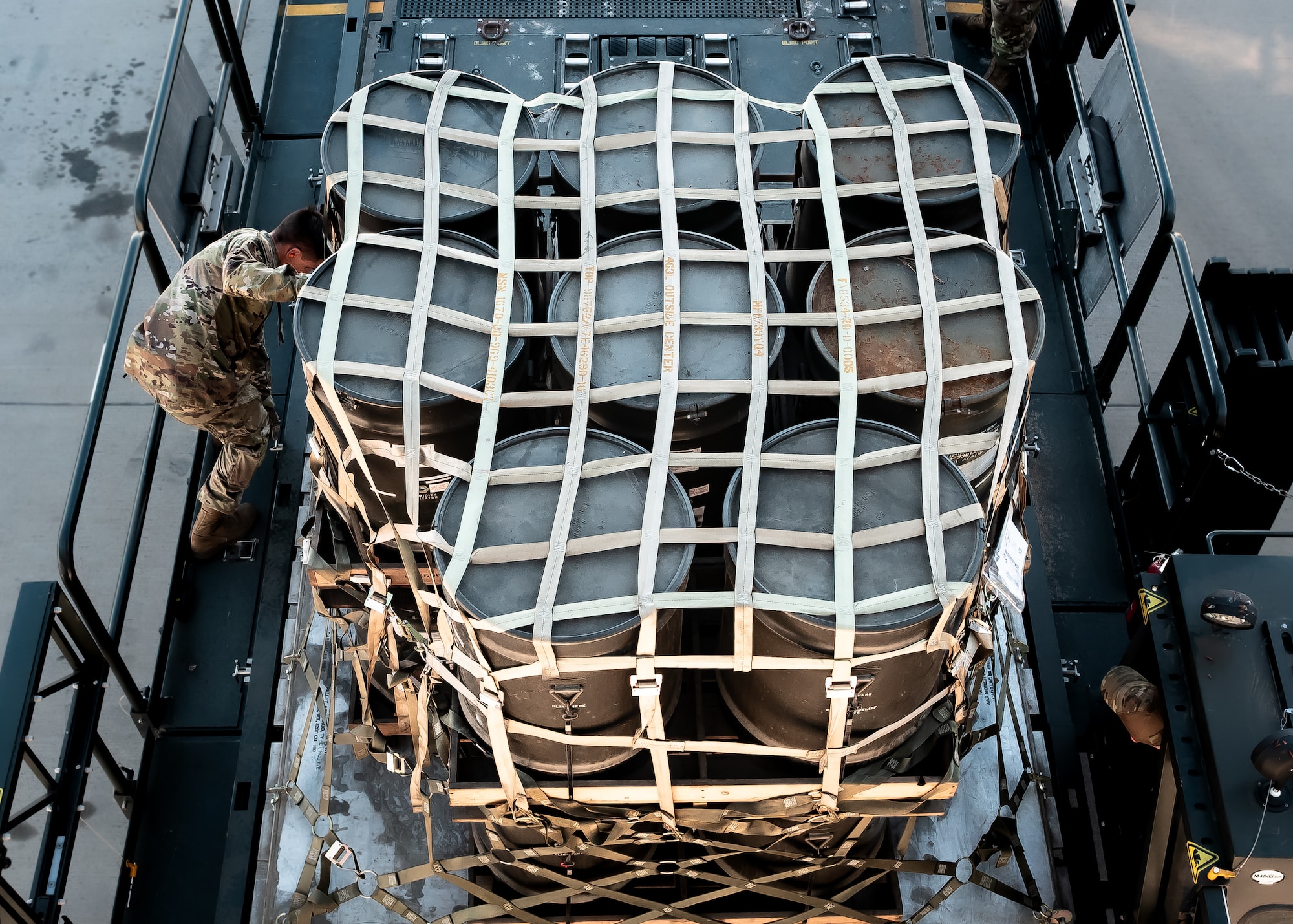 U.S. Air Force Tech. Sgt. Erik Swanberg, 161st Logistics Readiness Squadron air transportation operations center section supervisor, secures a cargo pallet of munitions tail kits during Special Assignment Airlift Mission