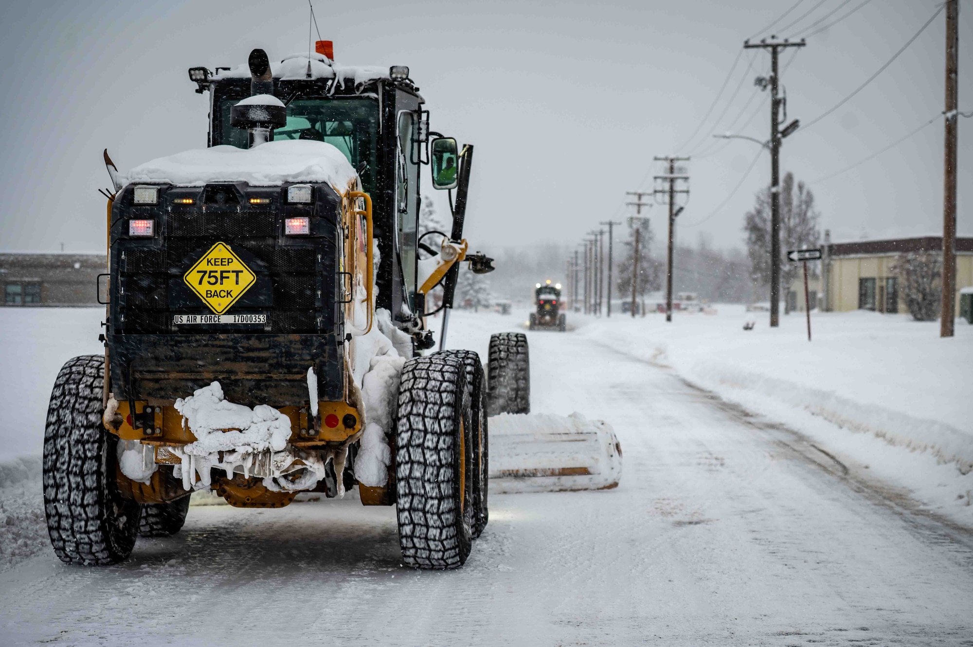 Members of the 773d Logistics Readiness Squadron operate road graders to level roads after heavy snowfall at Joint Base Elmendorf-Richardson, Alaska, Jan. 6, 2026. Snow removal operations maintain safe travel routes across the installation, ensuring personnel can reach work centers and mission-critical facilities. (U.S. Air Force photo by Senior Airman Hunter Hites)