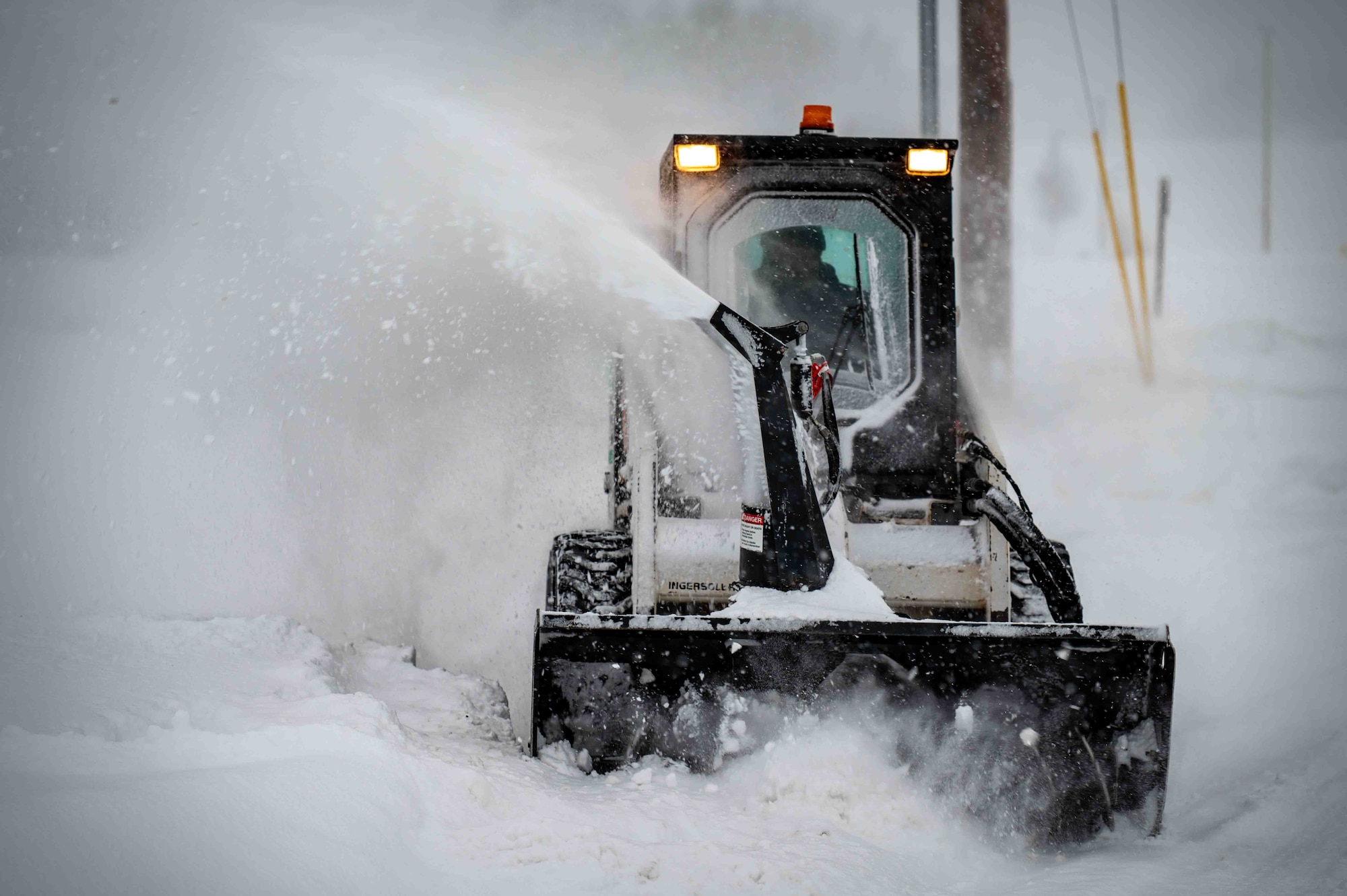 A member of the 773d Logistics Readiness Squadron operates snow blowing equipment to plow sidewalks at Joint Base Elmendorf-Richardson, Alaska, Jan. 6, 2026. Snow removal operations maintain safe travel routes across the installation, ensuring personnel can reach work centers and mission-critical facilities. (U.S. Air Force photo by Senior Airman Hunter Hites)