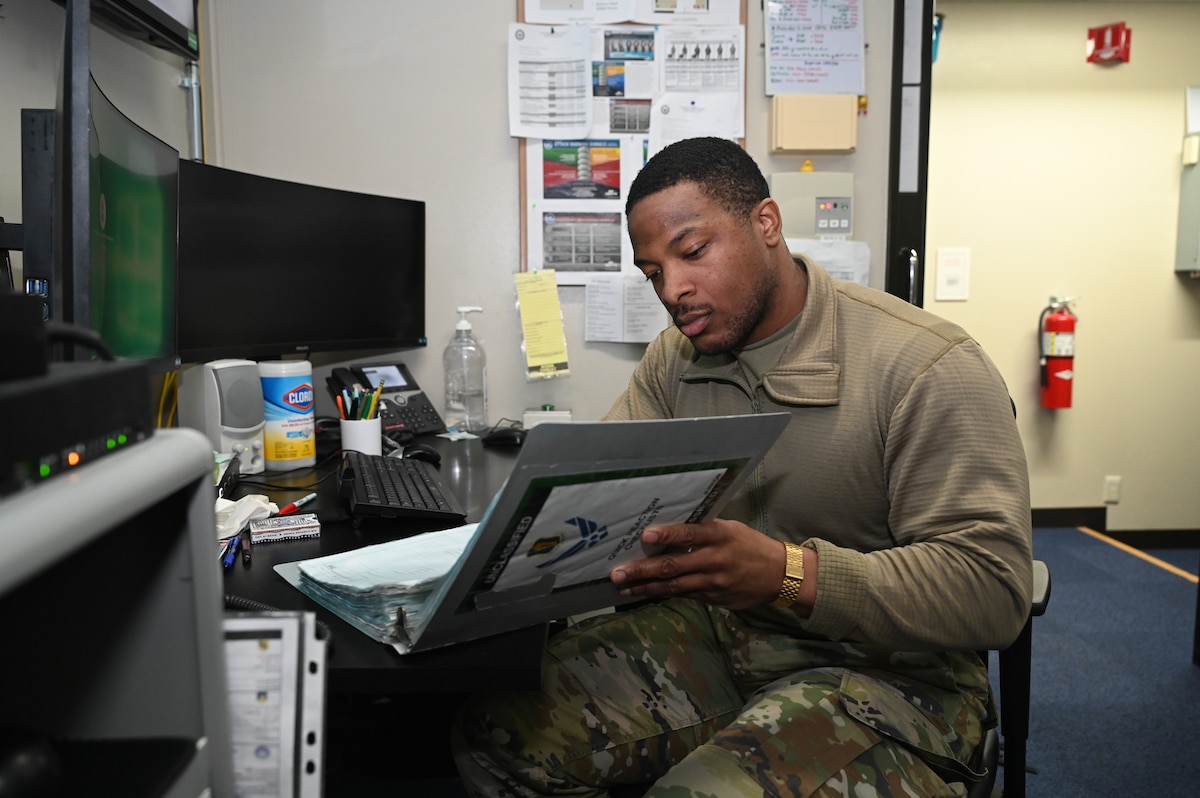 U.S. Air Force Airman Dijon Morris, 35th Fighter Wing Command Post emergency action controller, checks documents at Misawa Air Base, Japan.