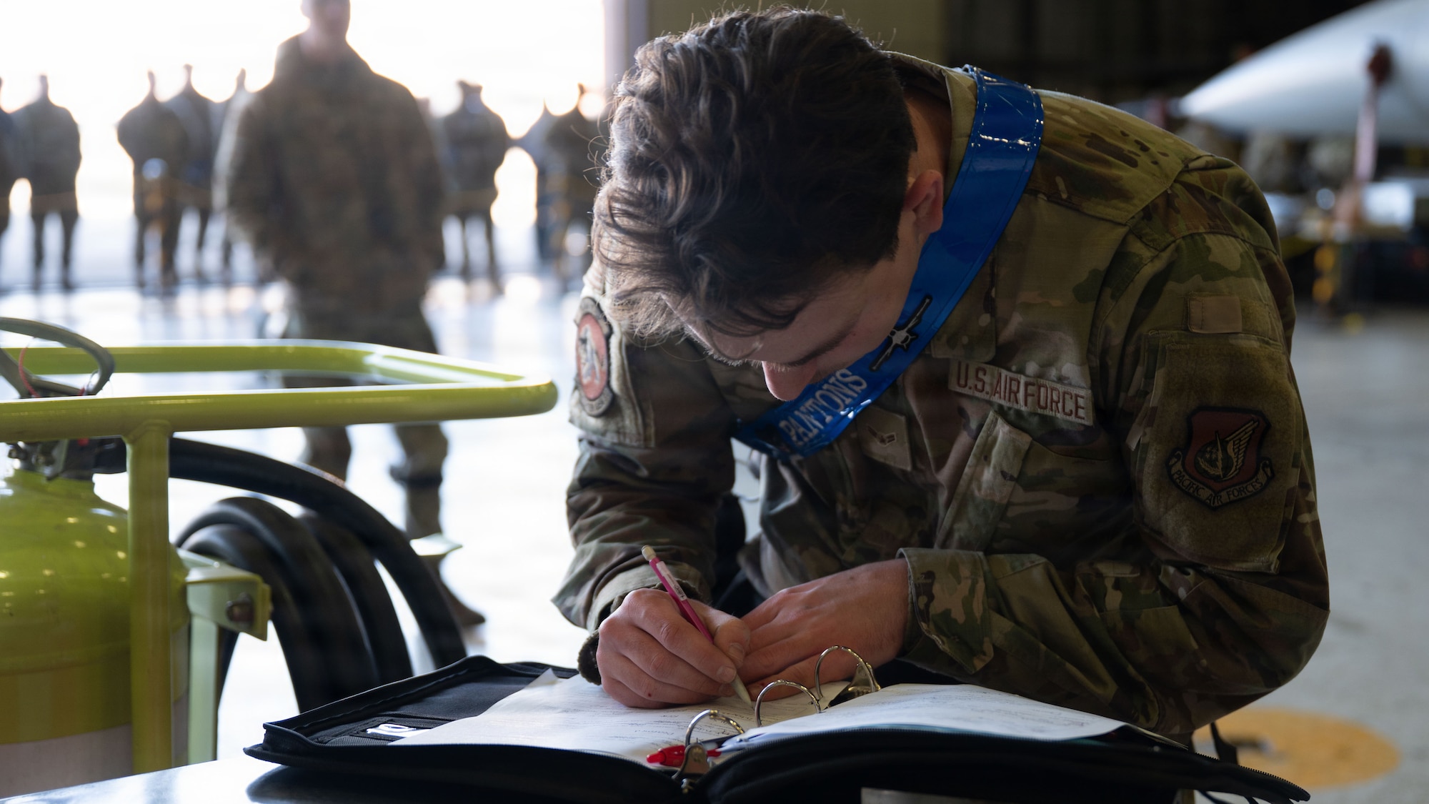 Spectators observe a member from the 35th Fighter Generation Squadron write a report during the 4th Quarter Ammo Bomb Building and Loading Competition at Osan Air Base, Republic of Korea, Jan. 8, 2026.