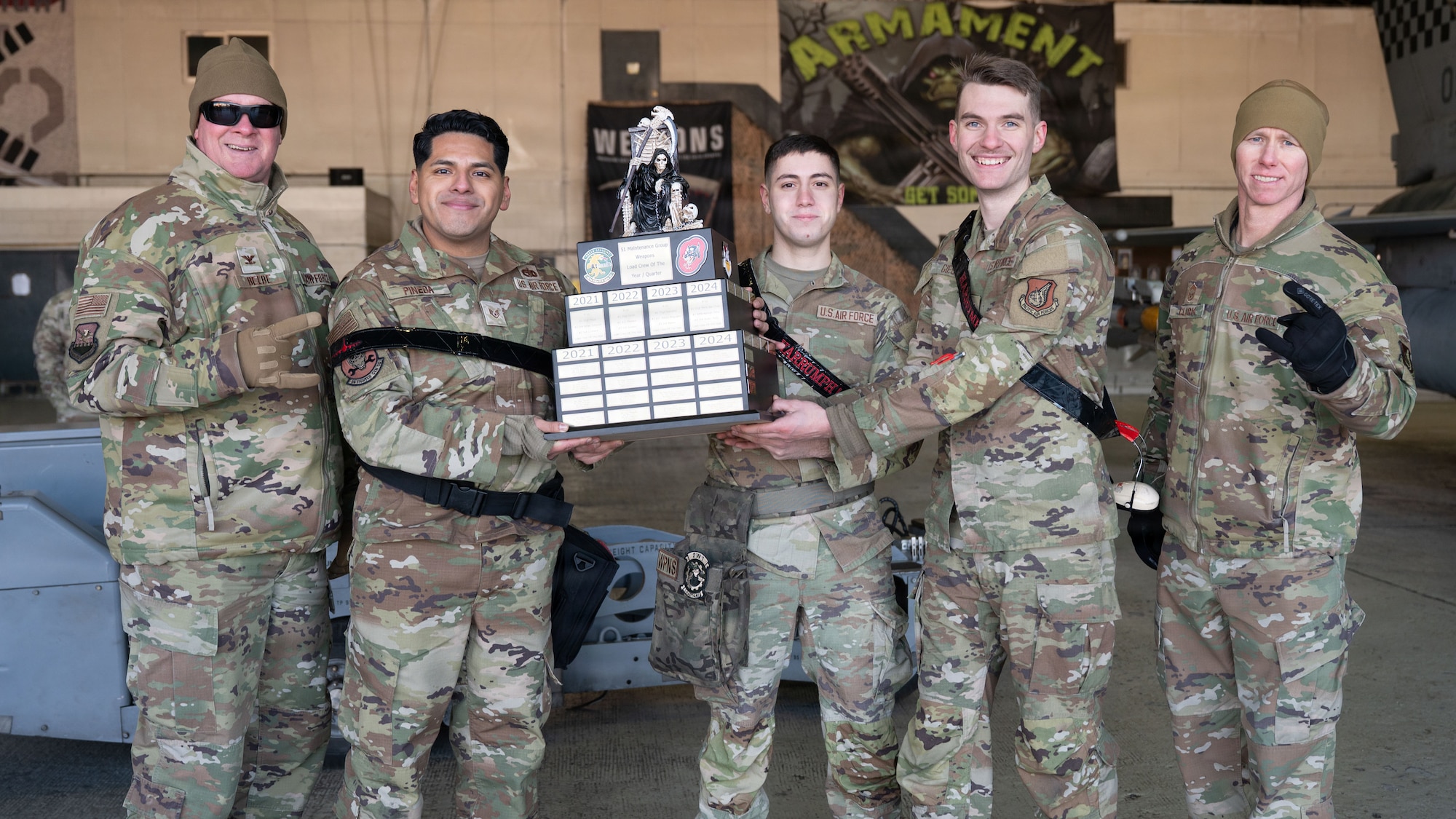 U.S. Air Force Col. Kenneth Beebe III, 51st Maintenance Group commander, far left, and Chief Master Sgt. Michael Clark, 51st MXG command chief, far right, pose with load winners of the 4th Quarter Ammo Bomb Building and Loading Competition at Osan Air Base, Republic of Korea, Jan. 8, 2026.