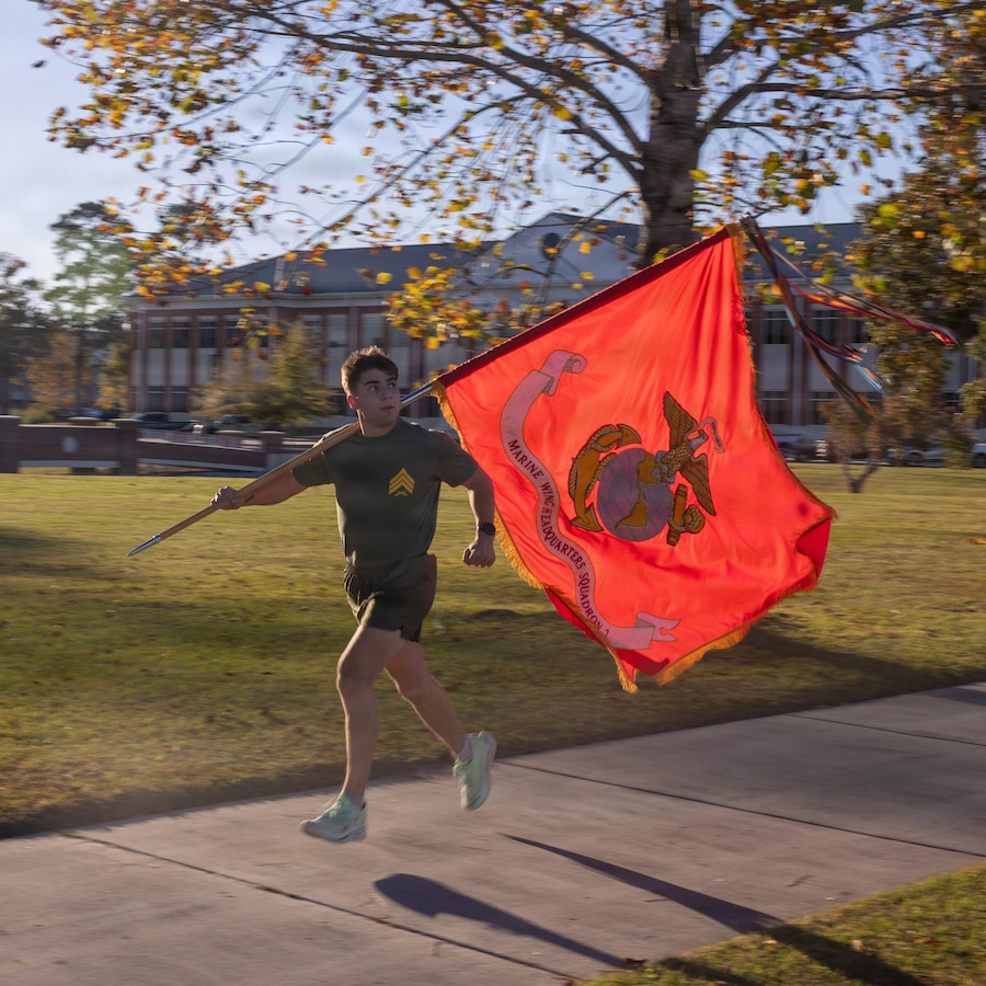 U.S. Marine Corps Sgt. Matthew Holder, from Alabama, a network administrator with Marine Wing Headquarters Squadron (MWHS) 2, 2nd Marine Aircraft Wing, runs with the squadron colors at Marine Corps Air Station Cherry Point, North Carolina, Nov. 5, 2025. U.S. Marines with MWHS-2 took part in a 250-mile relay run in celebration of the Marine Corps' 250th birthday. (U.S. Marine Corps photo by Cpl. Anakin Smith)