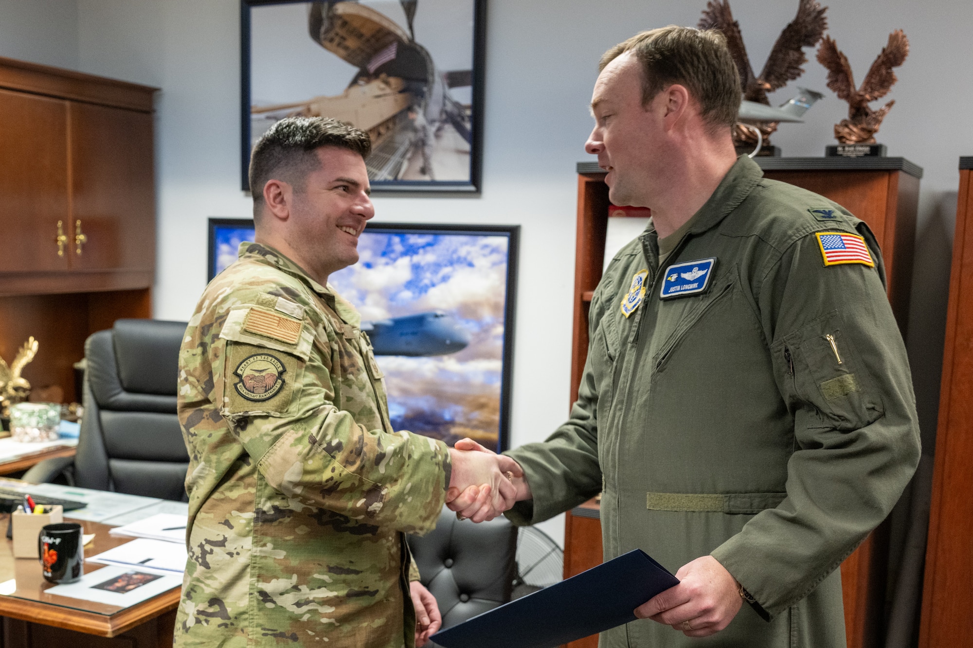 U.S. Air Force Senior Master Sgt. Nicholas Carone, left, 436th Aircraft Maintenance Squadron maintenance superintendent, shakes hands with Col. Justin Longmire, 436th Airlift Wing deputy commander, after being notified of his selection for promotion to the rank of Chief Master Sgt. at Dover Air Force Base, Delaware, Jan. 6, 2026. The selectees and their families were invited to a reception hosted by the Dover Chiefs’ Council. (U.S. Air Force photo by Mauricio Campino)