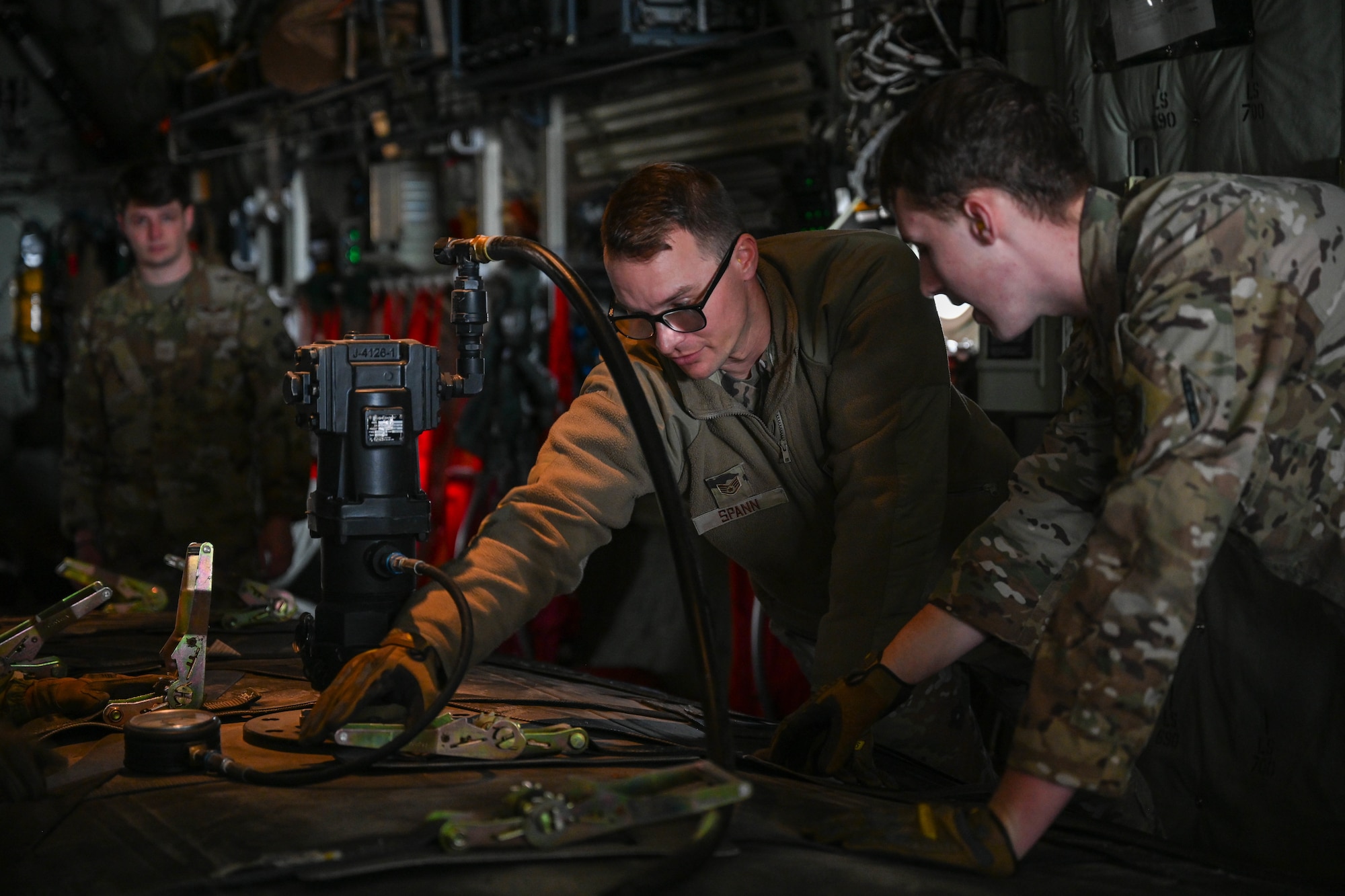 Airmen tighten cargo straps.