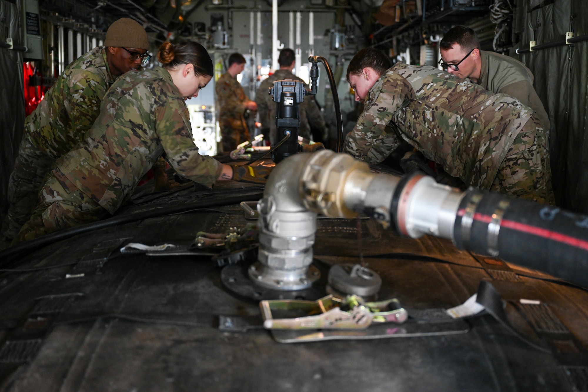 Airmen tighten cargo straps.