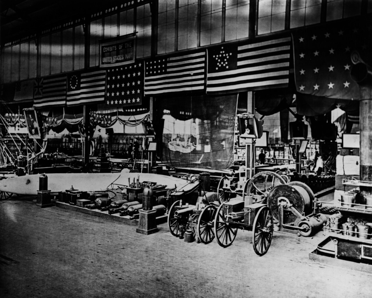 A variety of weapons and flags are displayed in a warehouse.