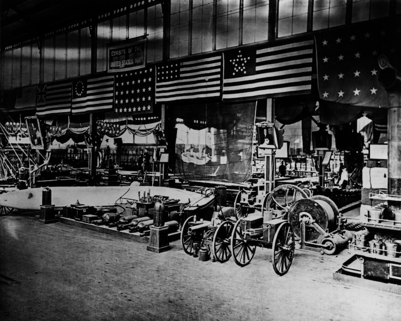 A variety of weapons and flags are displayed in a warehouse.