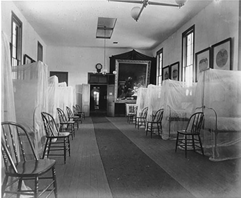 A hospital room is shown lines with lines of beds.