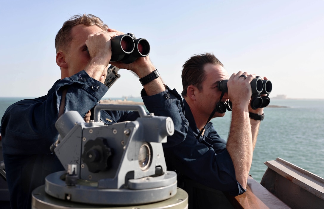 ARABIAN SEA (Dec. 30, 2025) U.S. Navy Cmdr. R.J. DaPrato, executive officer of the Arleigh Burke-class guided-missile destroyer USS Roosevelt (DDG 80), right, and U.S. Navy Ensign Zachary Lozano monitor maritime traffic from the bridge wing during a sea-and-anchor evolution in the Arabian Sea. Roosevelt is deployed to the U.S. 5th Fleet area of operations to support maritime security and stability in the U.S. Central Command area of responsibility. (U.S. Navy photo by Mass Communication Specialist 1st Class Indra Beaufort)