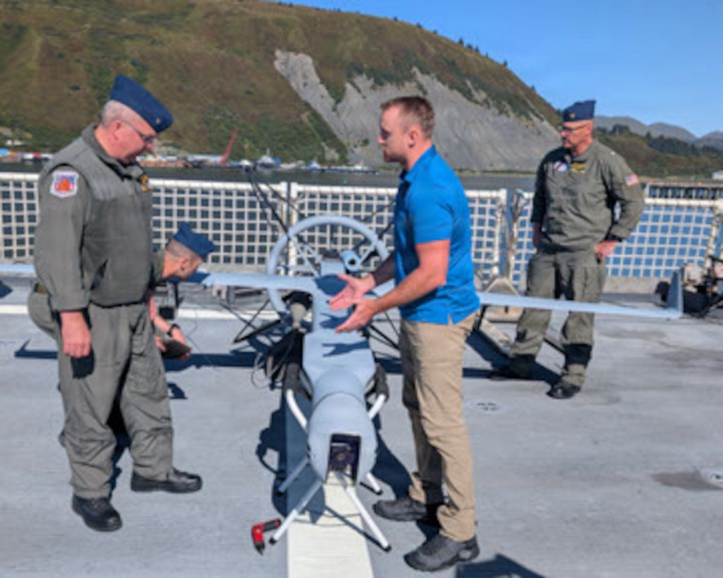 Civilian contractors aboard USCGC Kimball (WMSL 756) from Shield A.I. demonstrate the capabilities of the Vertical Takeoff and Landing Battery (V-BAT) unmanned aerial vehicle to Air Station Kodiak leadership on the flight deck, Sep. 12, 2025, in Kodiak, Alaska. Kimball utilized the V-BAT for several fisheries law enforcement boardings throughout the Alaska Patrol. (U.S. Coast Guard photo by Petty Officer 3rd Class Elizabeth Collins)