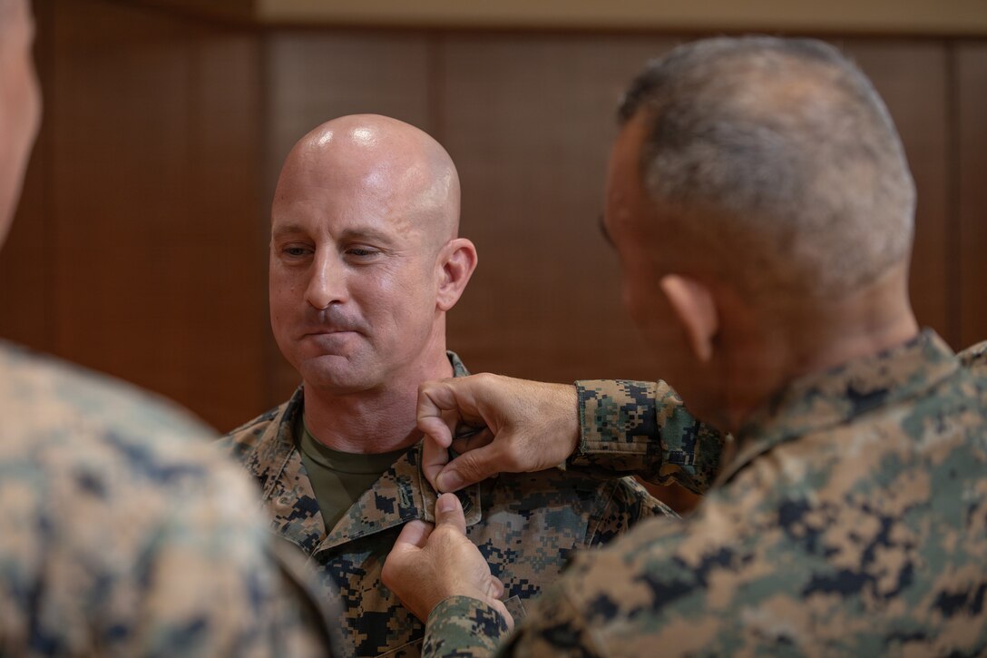 U.S. Marine Corps Sgt. Maj. Edwin A. Mota, command senior enlisted leader of Marine Forces Reserve and Marine Forces South, pins first sergeant ranks onto 1st Sgt. Joseph B. Stoker, an individual material readiness list coordinator with 4th Marine Aircraft Wing, at Marine Corps Support Facility, New Orleans, Jan. 7, 2025. Stoker became one of the first Marines to laterally transfer to first sergeant through the E-8 redesignation board pilot, a new program within the Marine Corps that allows qualified master sergeants to apply for redesignation as first sergeants. (U.S. Marine Corps photo by Lance Cpl. Van Hoang)