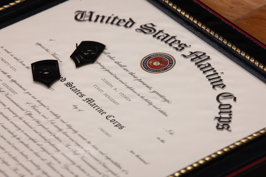 U.S. Marine Corps 1st Sgt. Joseph B. Stoker’s promotion warrant lays on a table with a pair of used master sergeant ranks after a redesignation ceremony, Marine Corps Support Facility, New Orleans, Jan. 7, 2025. Stoker became one of the first Marines to laterally transfer to first sergeant through the E-8 redesignation board pilot, a new program within the Marine Corps that allows qualified master sergeants to apply for redesignation as first sergeants. (U.S. Marine Corps photo by Lance Cpl. Van Hoang)