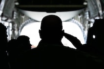 A photo of Airmen saluting over a casket in a C-17 Globemaster III.