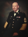handsome balding white man, non-smiling but with kind eyes, sitting in a U.S. Army dress uniform, shot from mid-thigh up in front of stormy cloud artist background, like an official glamour shot. very professional and reverent.