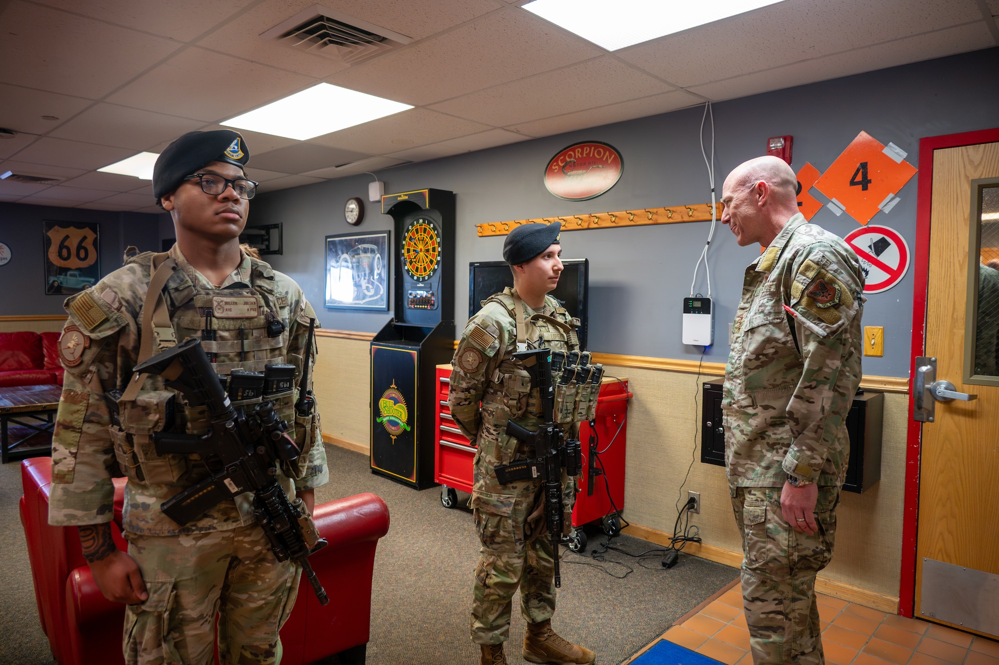 Three uniformed personnel converse with one another
