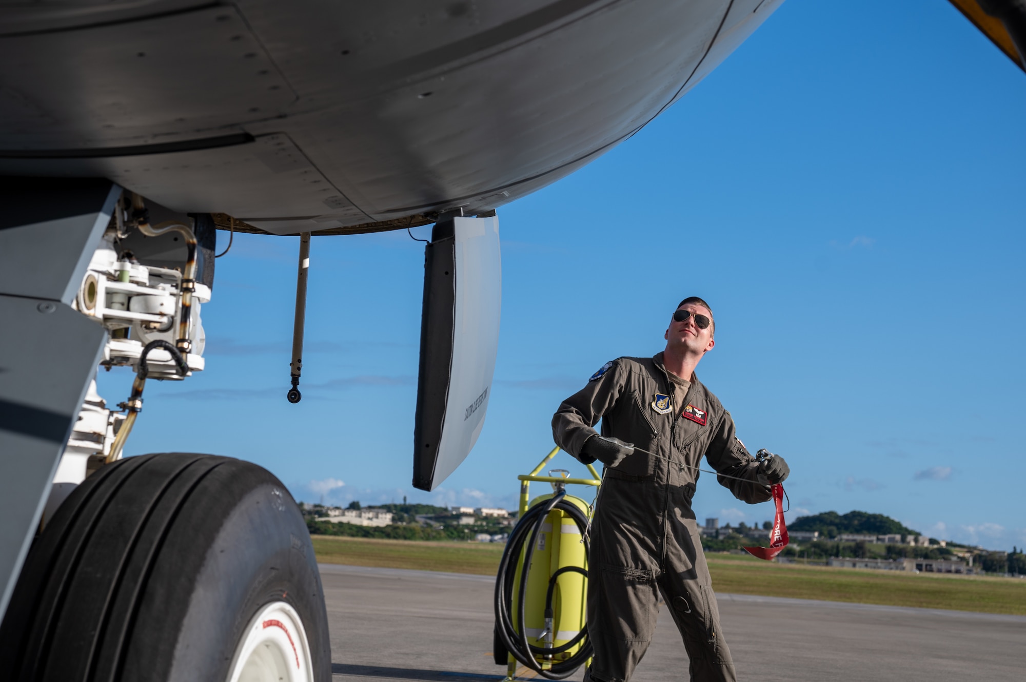 Pilot with sunglasses on stands next to KC-135 Wheel
