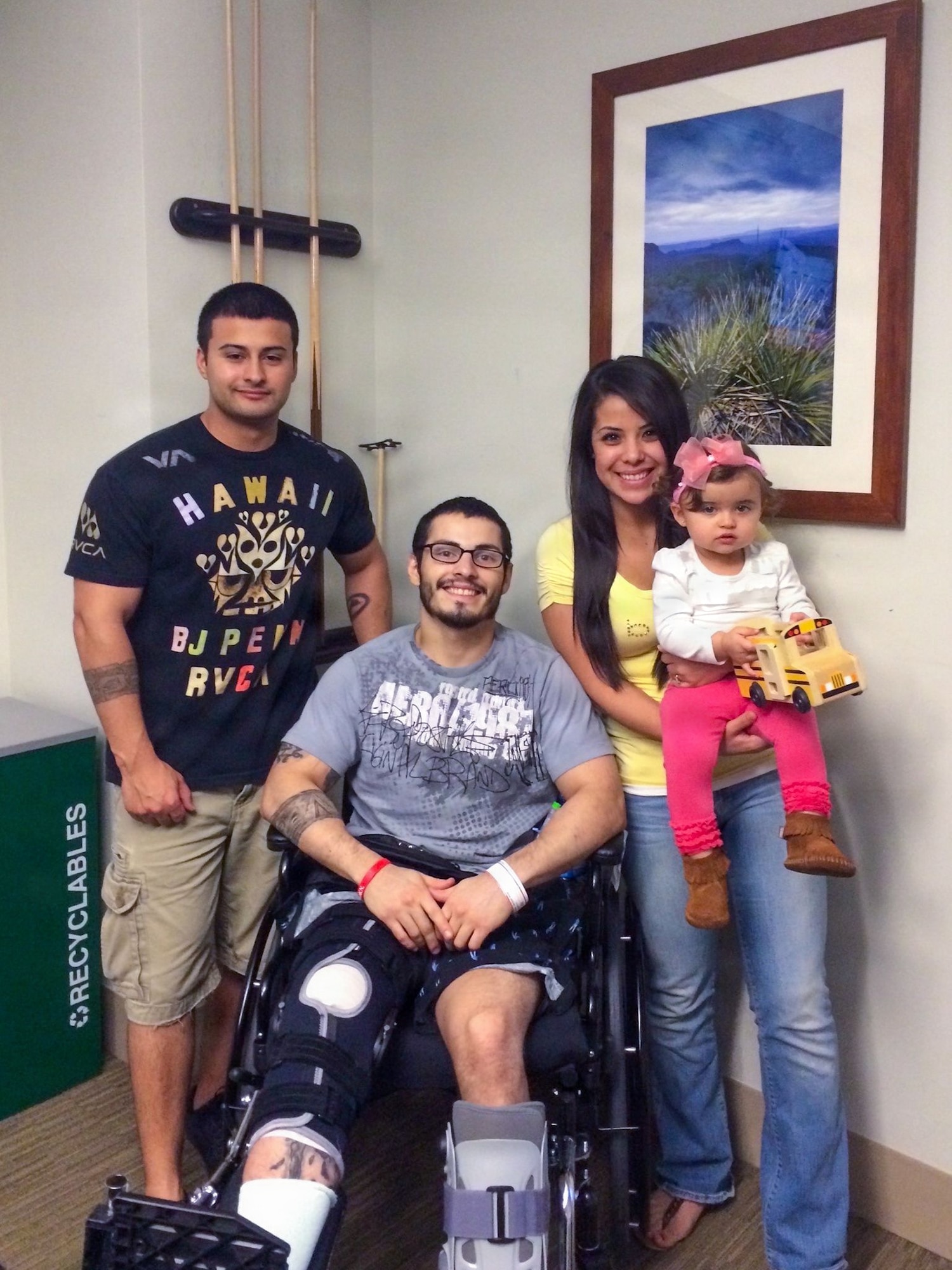 An Airman takes a photo with family members during an injury rehabilitation.